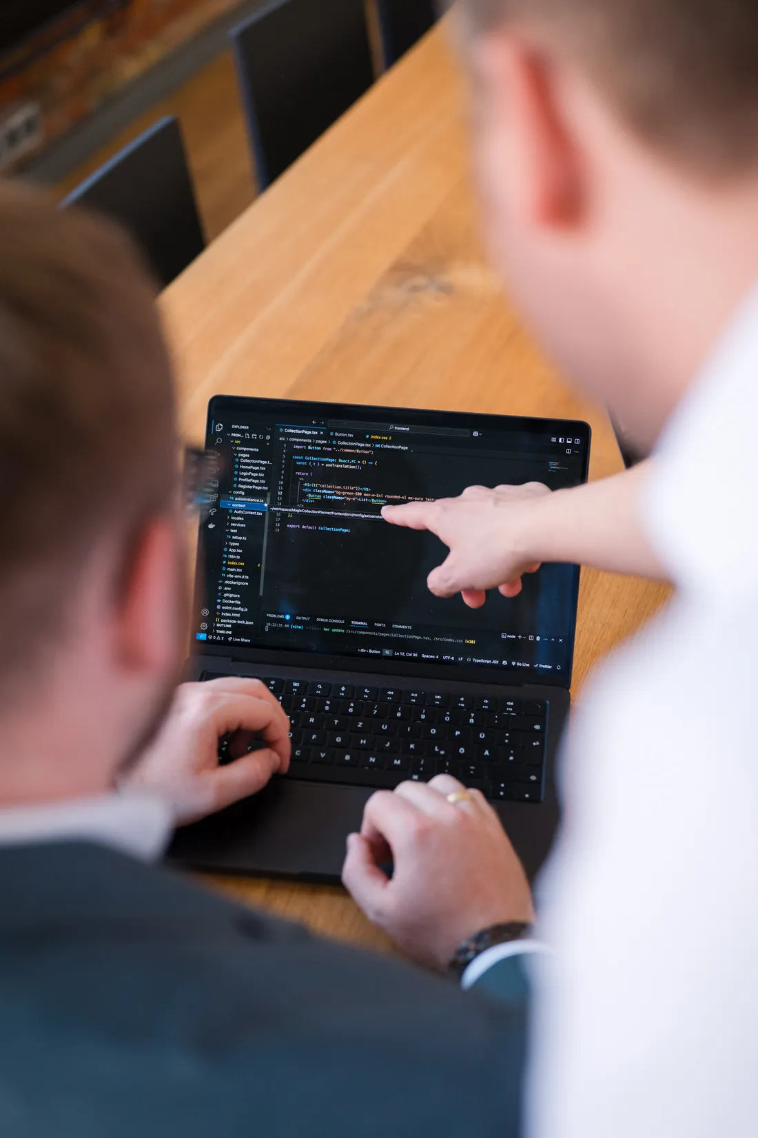 Zwei Entwickler besprechen Quellcode an einem Laptop